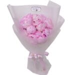 Pink peonies with bouquet wrapping and ribbon