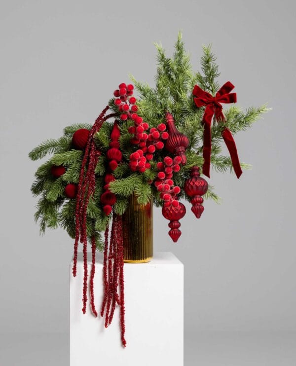 Majestic Red arrangement with pine and crimson ornaments in a gold vase