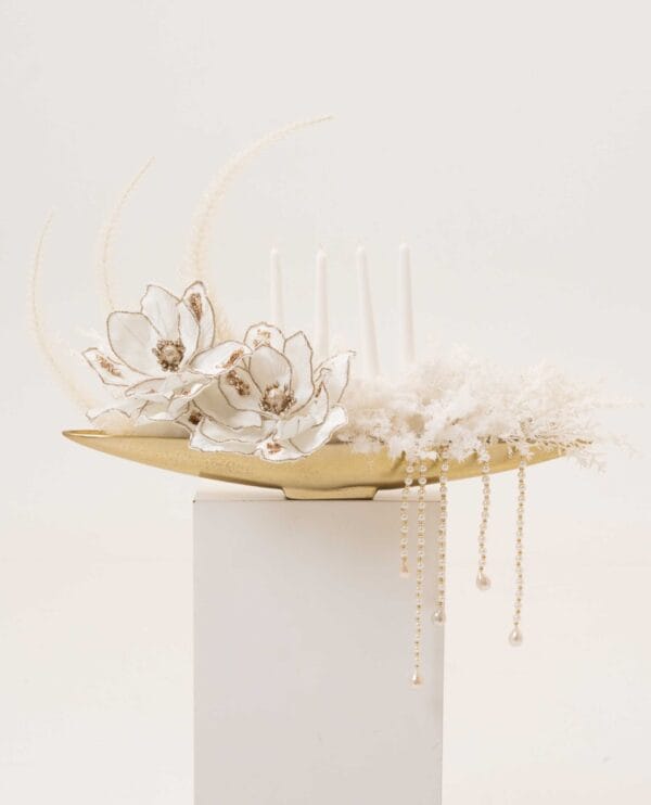 Golden Drift magnolia-style arrangement with pearls on a gold tray