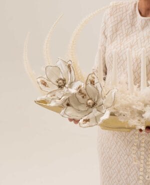 Golden Drift magnolia-style arrangement with pearls on a gold tray
